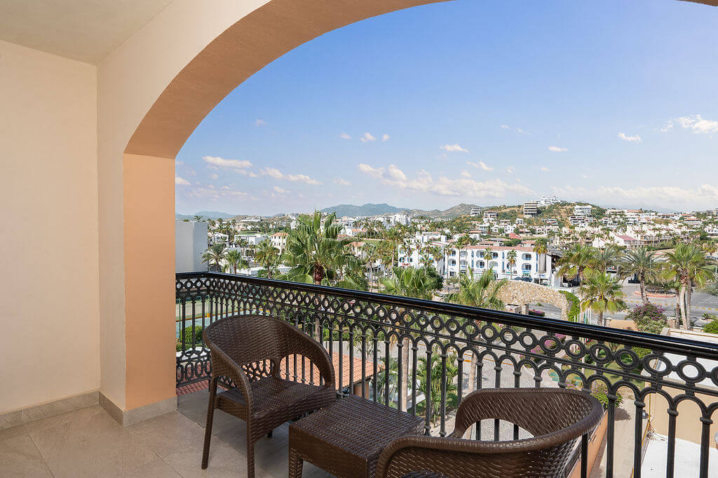Arched balcony with chairs looking out to the town and hills