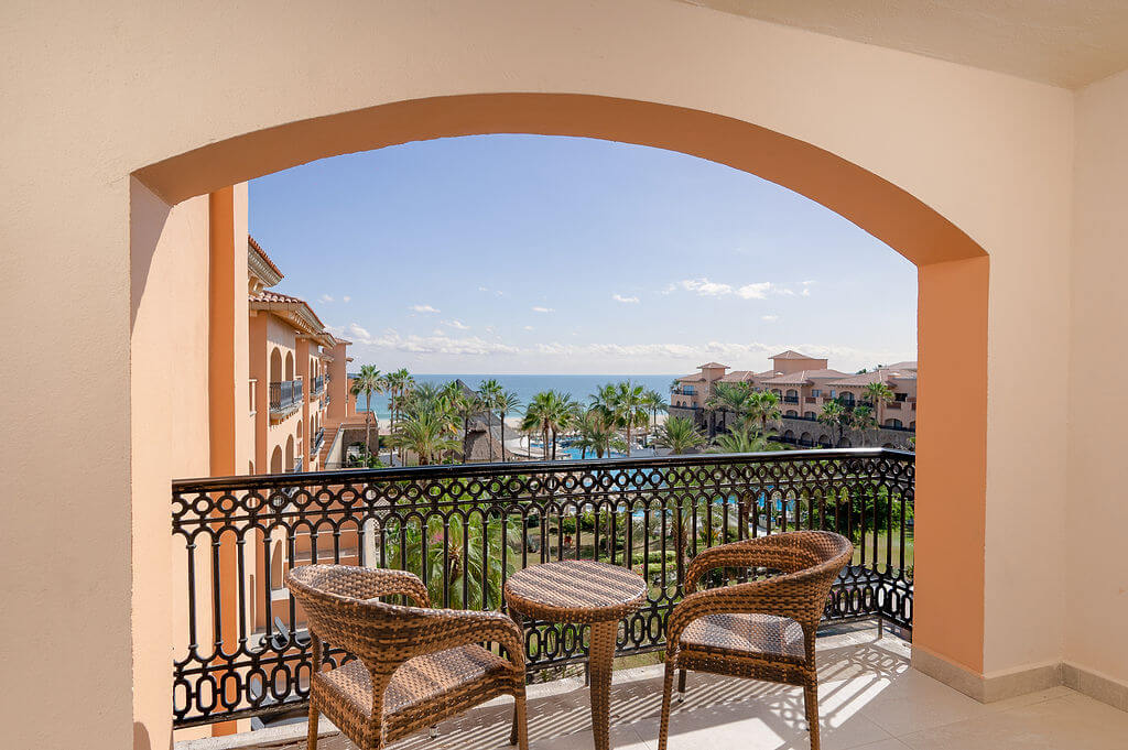 Arched balcony overlooking gardens, pool and the sea