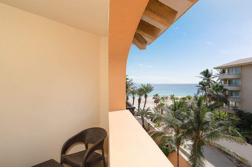 Side view of the beach and sea between palm trees from the balcony